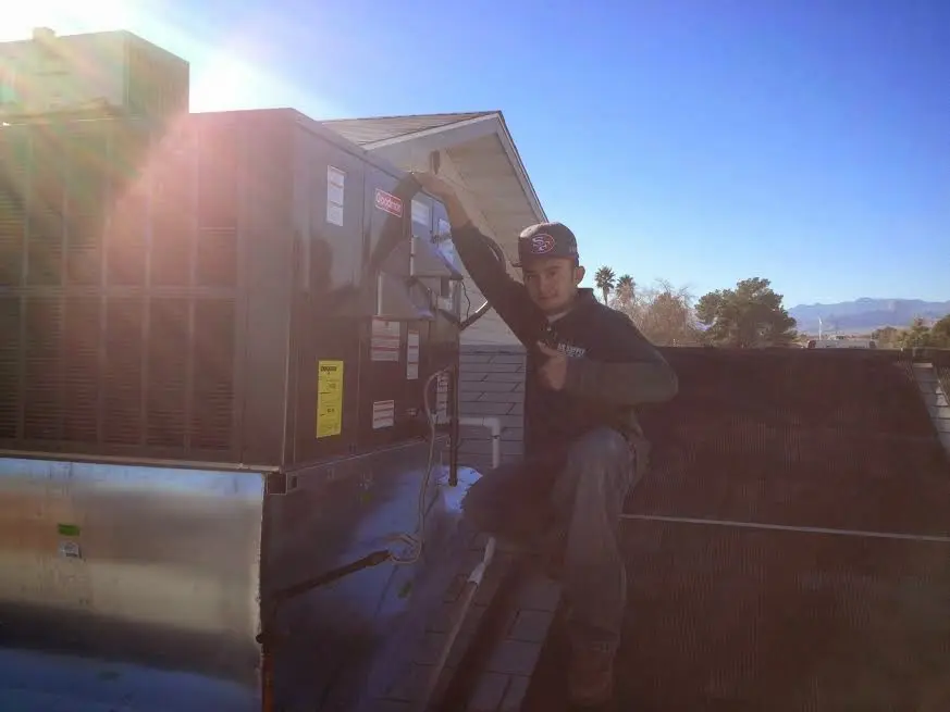HVAC technician performing AC Tune-Up on a rooftop unit in Nanakuli